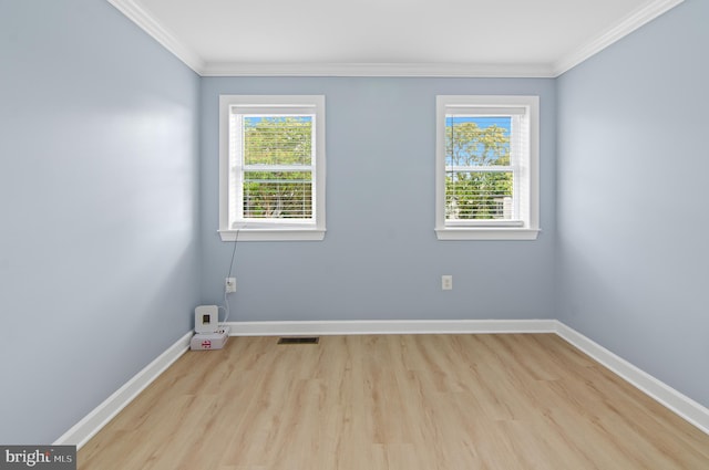 spare room with ornamental molding and light hardwood / wood-style flooring