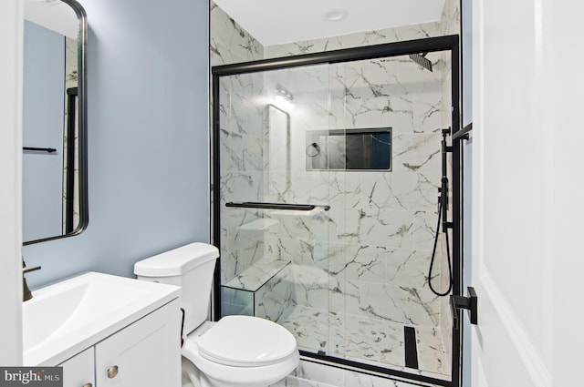 bathroom featuring vanity, toilet, and a shower with door