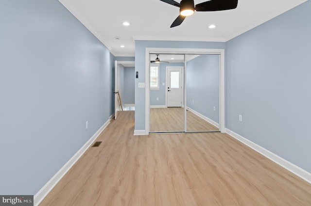 unfurnished bedroom featuring light hardwood / wood-style flooring, ornamental molding, a closet, and ceiling fan