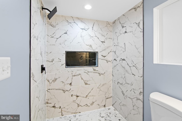 bathroom with tiled shower and toilet