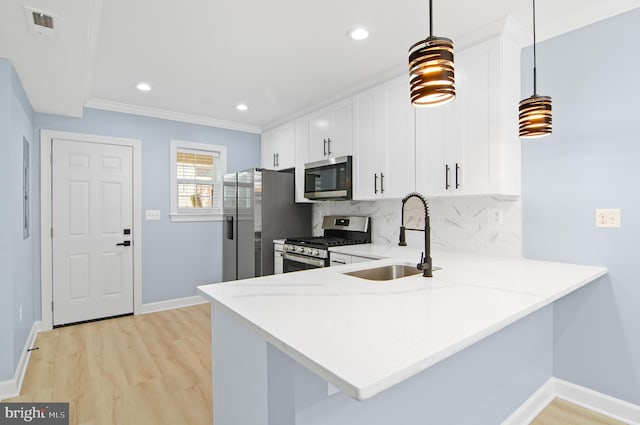 kitchen with stainless steel appliances, kitchen peninsula, hanging light fixtures, and sink