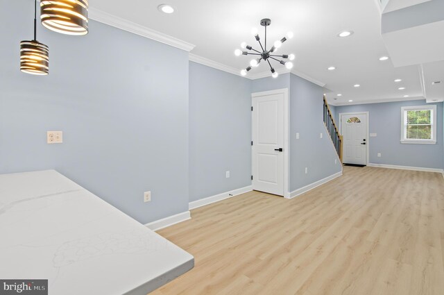 unfurnished dining area with crown molding, an inviting chandelier, and light hardwood / wood-style flooring