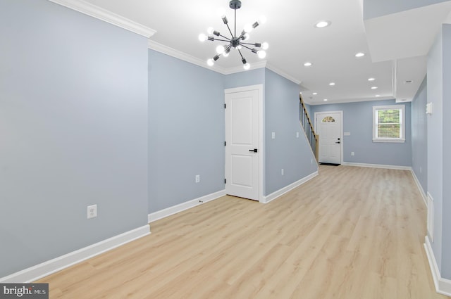 unfurnished living room featuring light wood-type flooring, ornamental molding, and an inviting chandelier