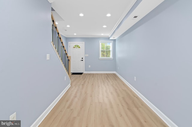 interior space featuring light wood-type flooring and crown molding