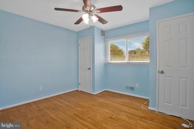 empty room with ceiling fan and light hardwood / wood-style floors