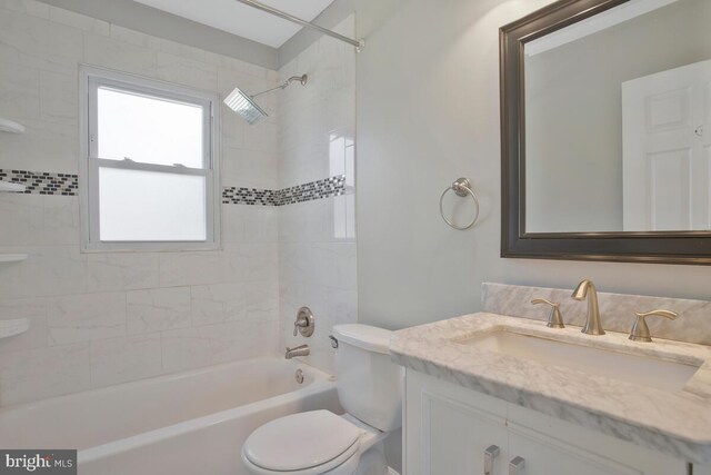 full bathroom featuring toilet, tiled shower / bath combo, and vanity