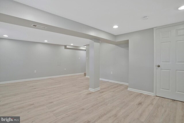 basement with light hardwood / wood-style flooring