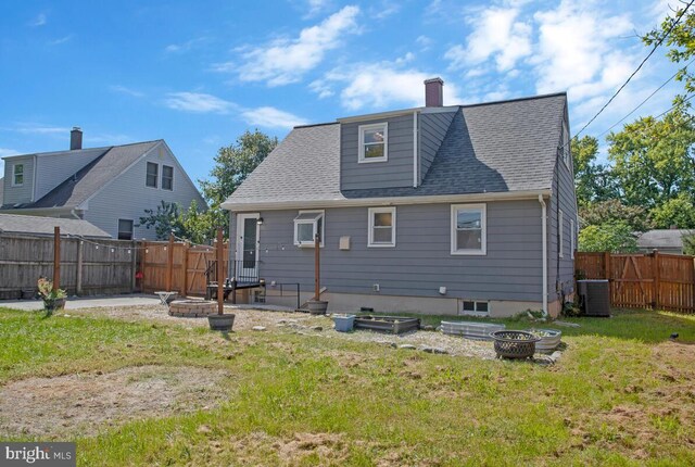 back of property with a yard, central AC unit, a patio area, and an outdoor fire pit