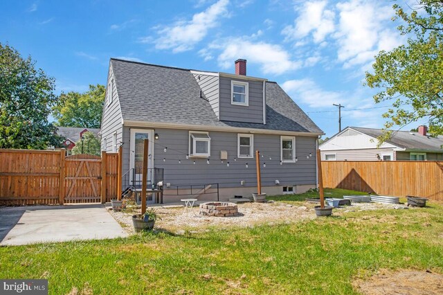 rear view of house with a fire pit, a yard, and a patio