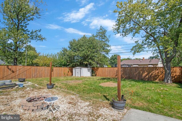 view of yard with a fire pit and a storage shed