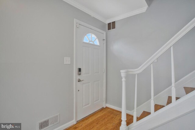 entryway featuring ornamental molding and wood-type flooring