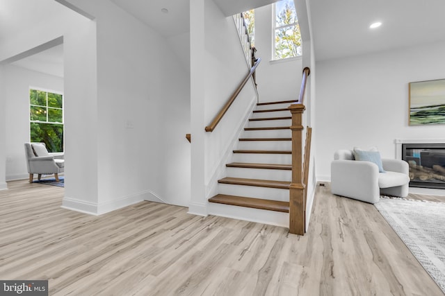 staircase with hardwood / wood-style floors and a healthy amount of sunlight