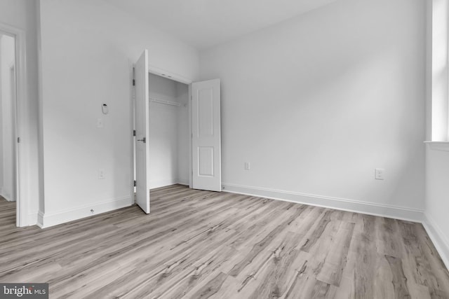 unfurnished bedroom with a closet and light wood-type flooring