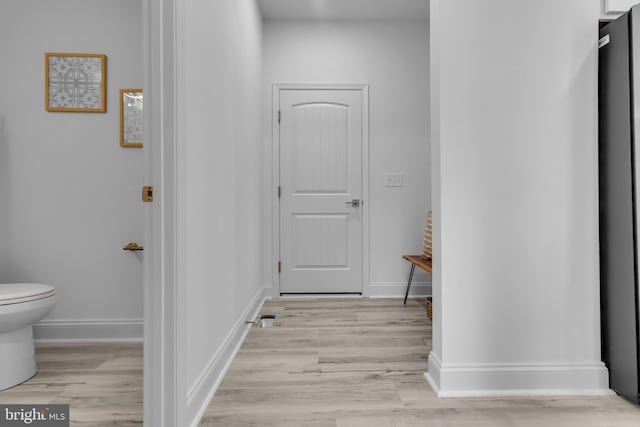 corridor with light hardwood / wood-style floors