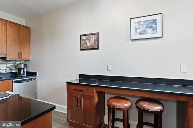 kitchen with dishwasher, tasteful backsplash, and dark tile patterned floors