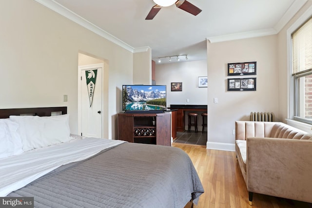 bedroom with ceiling fan, crown molding, and light hardwood / wood-style flooring