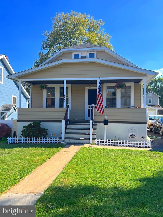 view of front of house with a front yard and covered porch