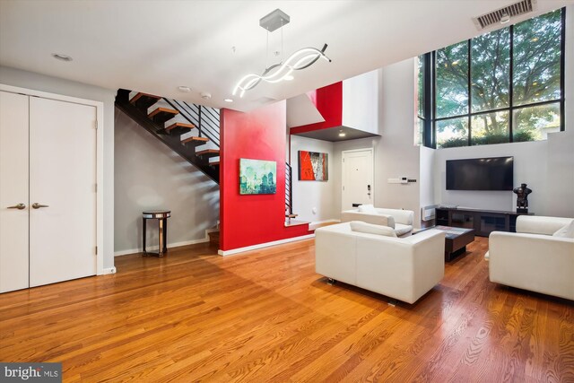 living room with a towering ceiling and hardwood / wood-style flooring