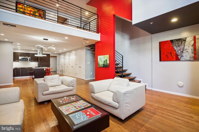 living room featuring a towering ceiling and hardwood / wood-style flooring