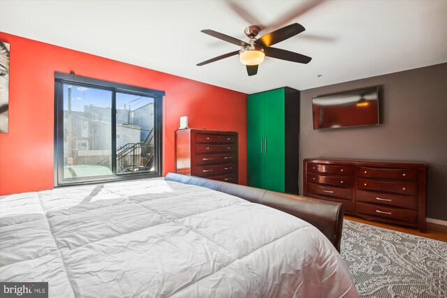 bedroom with light hardwood / wood-style flooring, access to exterior, and ceiling fan