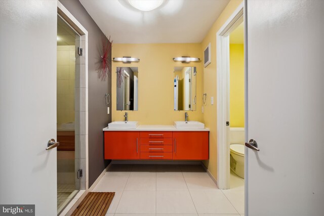 bathroom with vanity, toilet, a shower with shower door, and tile patterned flooring