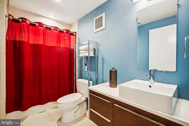 bathroom featuring a shower with shower curtain, vanity, toilet, and tile patterned floors