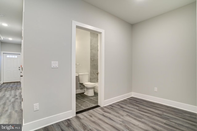 unfurnished bedroom with wood-type flooring and ensuite bath