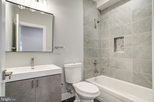 full bathroom featuring tiled shower / bath, vanity, and toilet