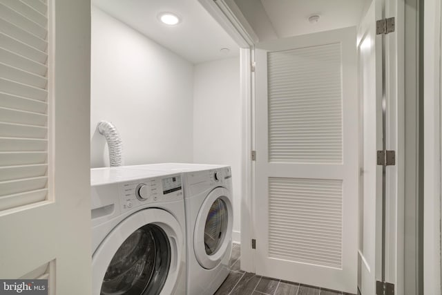 laundry area with washing machine and clothes dryer and dark hardwood / wood-style floors