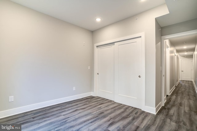 unfurnished bedroom featuring dark hardwood / wood-style floors and a closet