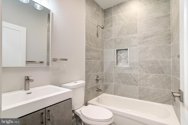 full bathroom with tiled shower / bath, vanity, and toilet