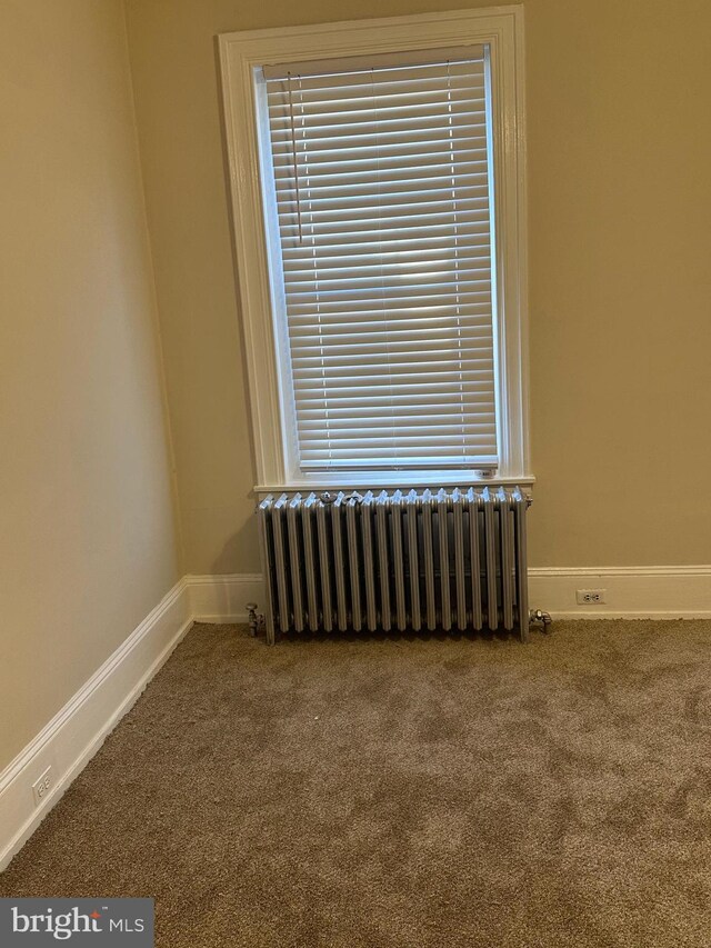 empty room with carpet and radiator