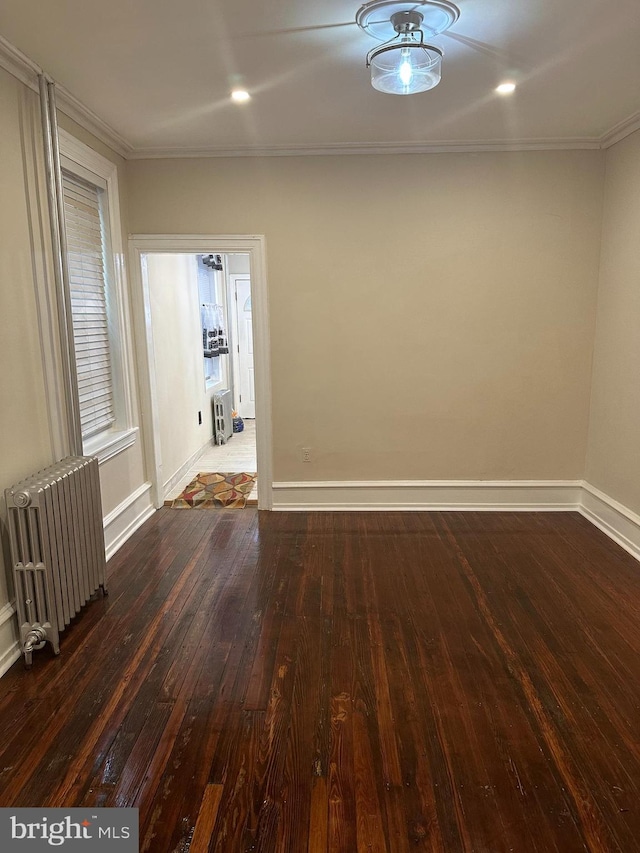 spare room featuring ornamental molding, radiator, and wood-type flooring