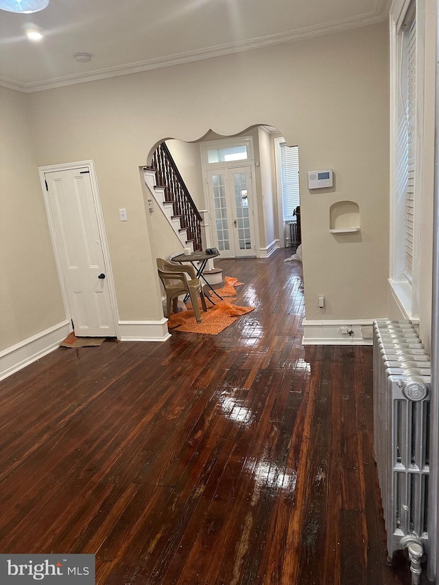 entrance foyer featuring crown molding, dark wood-type flooring, and radiator heating unit