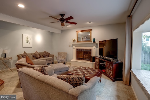 living room with light colored carpet, a tile fireplace, and ceiling fan