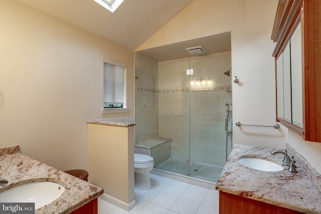 bathroom featuring vanity, lofted ceiling with skylight, a shower with door, and toilet