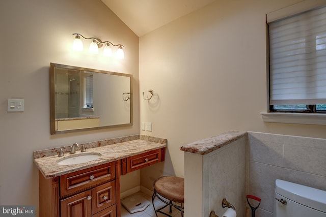 bathroom with vanity, lofted ceiling, toilet, and tile patterned flooring