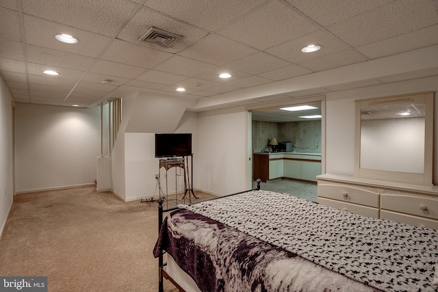 carpeted bedroom featuring a drop ceiling