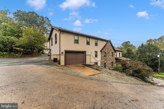 view of side of home featuring central AC unit and a garage