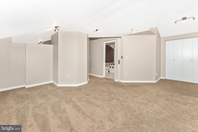 carpeted empty room with lofted ceiling