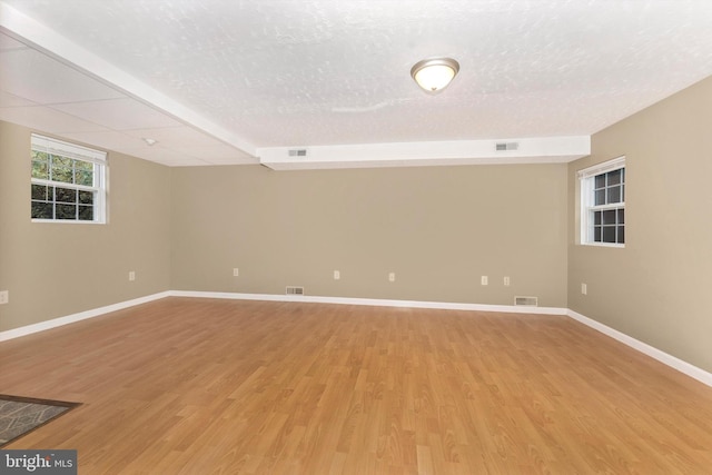 unfurnished room with a textured ceiling and light hardwood / wood-style flooring