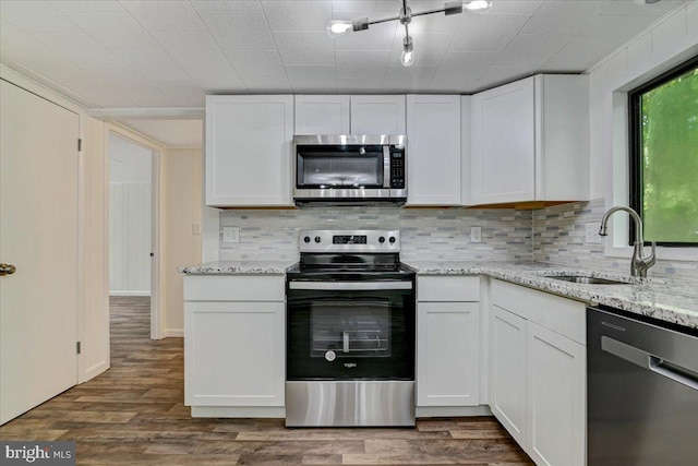 kitchen featuring stainless steel appliances, white cabinetry, and sink