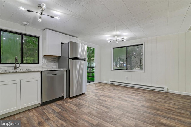 kitchen featuring a baseboard heating unit, sink, light stone countertops, white cabinetry, and stainless steel appliances