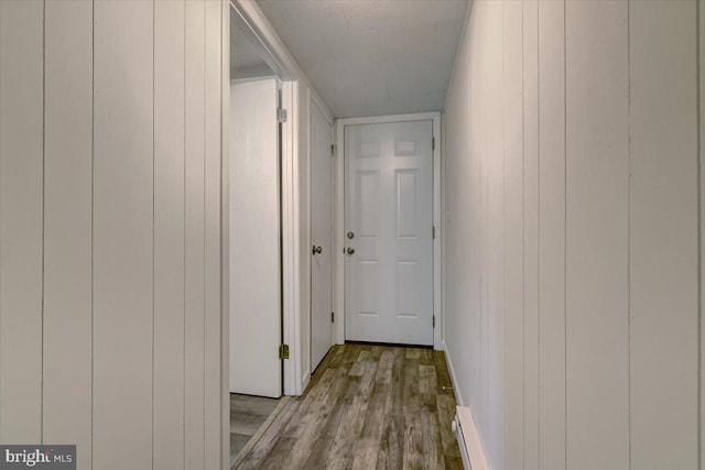 corridor with wooden walls and light wood-type flooring