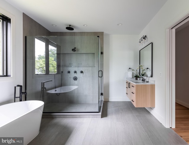 bathroom featuring independent shower and bath, wood-type flooring, and vanity