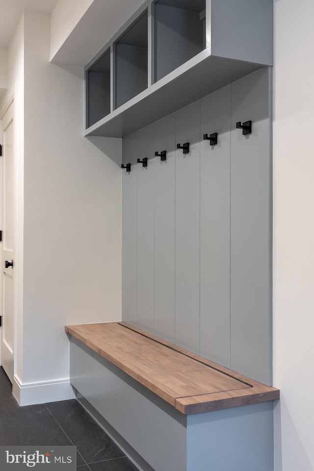 mudroom with dark tile patterned floors