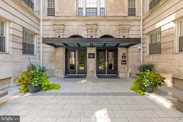 view of exterior entry featuring french doors and stone siding