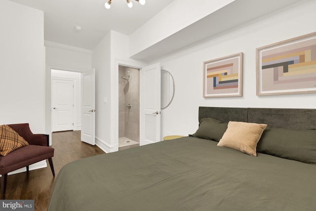 bedroom featuring ornamental molding, dark wood-type flooring, and ensuite bathroom