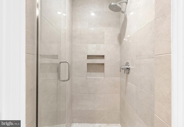 bathroom featuring a shower with door