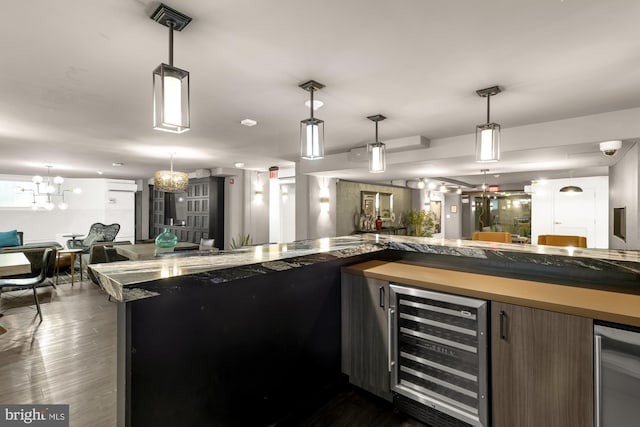 bar featuring an inviting chandelier, beverage cooler, decorative light fixtures, and dark hardwood / wood-style flooring